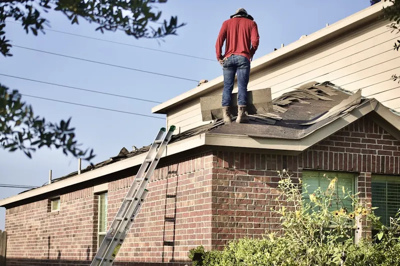 Professional roofer working on a residential roof in West Union